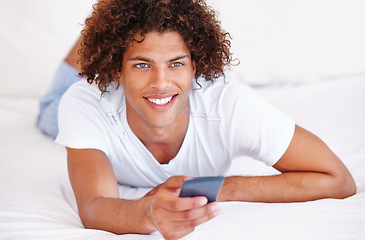 Image showing Man, remote control and watching tv in bed, relaxing and entertainment on cable show at home. Male person, bedroom and broadcast channel or comedy, subscription and streaming service for program