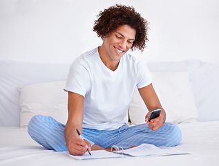 Image showing Man, writer and planning in journal, writing ideas and inspiration or research in bed at home. Male person, author and notes in book for project, brainstorming and smartphone for info in bedroom