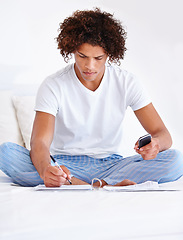 Image showing Man, freelancer and planning in journal, writing ideas and inspiration or research in bed at home. Male person, remote work and notes in book, brainstorming and smartphone for internet in bedroom