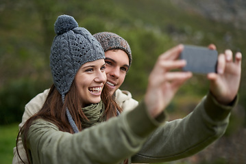 Image showing Couple, selfie and smile while hiking in nature, smartphone and capture moment in outdoors. People, happy and picture for memory and exploring wilderness, trekking and photograph for social media