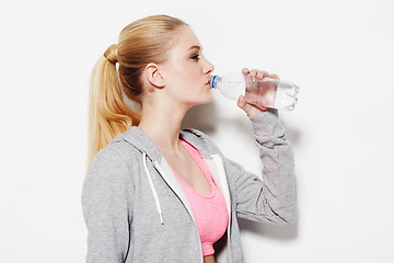 Image showing Woman, drinking water and workout in studio profile, thinking and vision for fitness by white background. Girl, model and person with bottle, liquid and hydration for detox, wellness and nutrition