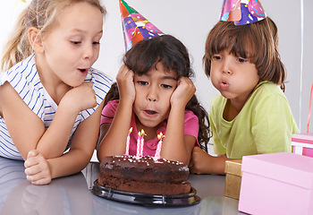 Image showing Friends, children and birthday cake, blowing candles at party with people for celebration, youth and dessert. Special day, together in festive mood and kids smile for social event with chocolate