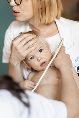 Image showing Small child being checked for heart murmur by heart ultrasound exam by cardiologist as part of regular medical checkout at pediatrician.