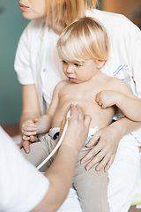 Image showing Small child being checked for heart murmur by heart ultrasound exam by cardiologist as part of regular medical checkout at pediatrician.