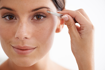 Image showing Woman, portrait and plucking eyebrow with tweezers for beauty and self care in bathroom. Makeup, routine and girl with hair removal, tools and facial grooming or cleaning for skincare and cosmetics