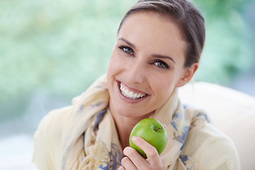 Image showing Portrait, apartment or happy woman with apple for healthy or balanced diet with nutrition or vitamins. Face, chair or vegan person eating fresh fruit, food or fibre for organic wellness in lounge
