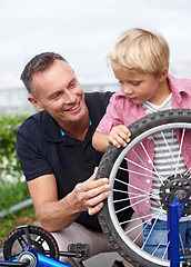 Image showing Bicycle, wheel or repair with father and son outdoor in neighborhood for learning or child development. Family, street and fixing with man parent teaching young boy tyre maintenance for cycling