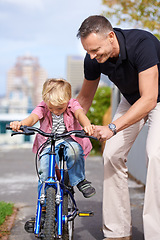 Image showing Bicycle, teaching and father with boy child in a road for help, learning or outdoor ride together. Love, family or parent with kid in a street for cycling assistance, bonding and support or safety