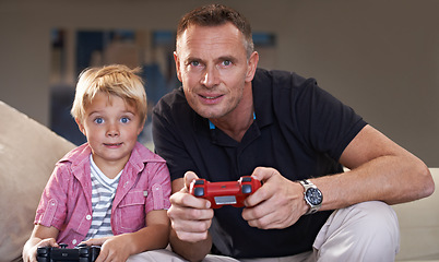 Image showing Family, father and serious son gaming on sofa in living room of home together for love, bonding or competition. Video game, controller for next level and gamer dad with boy child in apartment