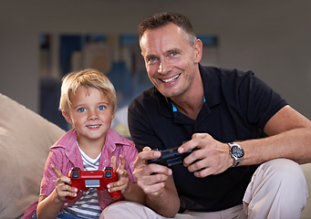 Image showing Family, father and son gaming on sofa in living room of home together for love, competition or child development. Video game, controller and next level with man parent gamer teaching boy child