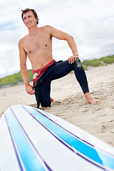 Image showing Beach, happy man or ready to start surfing with surfboard on vacation or adventure for fitness or travel. Smile, waiting or athlete at sea on holiday in Hawaii or ocean for wellness or extreme sports