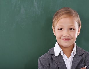 Image showing Child, portrait and chalkboard for school learning in classroom for education, writing or homework. Female person, uniform and kindergarten development or brainstorming or knowledge, growth or mockup