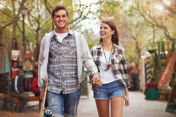 Image showing Smile, walking and couple holding hands on city journey, morning trip or weekend tour of urban Spain for outdoor adventure. Love, skateboard and young people bonding together on relax commute