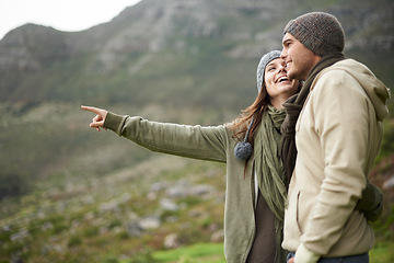 Image showing Smile, hiking and pointing with couple in mountains together for love, dating or sightseeing. Travel, environment or view with happy young man and woman in nature for adventure, holiday or vacation