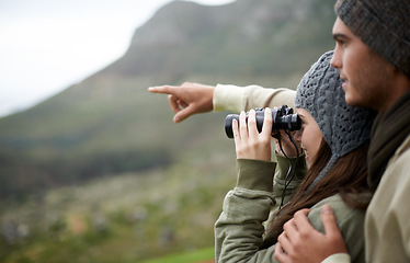 Image showing Couple with binoculars, nature and mountains for travel journey, adventure and hiking or explore together. Man and woman trekking, pointing with outdoor search, vision or birdwatching lens in tourism