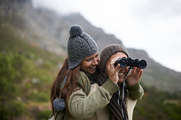 Image showing Happy couple, binoculars in nature and mountains for travel journey, adventure and hiking or explore together. Man and woman trekking for outdoor search, vision or birdwatching lens of winter tourism