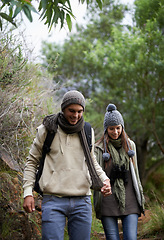 Image showing Couple, happy and hiking in forest or holding hands with travel, adventure and nature for wellness or fitness. Man, woman and trekking in woods for cardio, exercise or workout with view or backpack