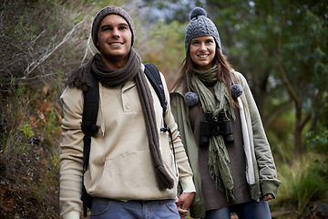 Image showing Couple, happy and hiking in forest with holding hands for travel, adventure or wellness and fitness. Man, woman and trekking outdoor in woods for cardio, exercise or workout with smile or backpack