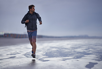 Image showing Running, beach and man with vacation, travel and exercise with nature, explore and ocean. Person, runner and guy with fun, water and sunset with wellness and breathing with workout, energy and Miami