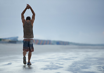 Image showing Back, stretching and beach with man, fitness and vacation with summer break and morning. Person, ocean and guy with holiday and seaside with with exercise, peaceful and water with health and wellness