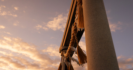 Image showing Torii gate, sunset and sky in Japan with clouds, zen and spiritual history on travel adventure. Shinto architecture, Asian culture and calm nature on Japanese landscape with sacred monument at shrine