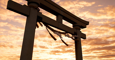 Image showing Torii gate, sunset and cloudy sky with zen, peace and spiritual history on travel adventure in Japan. Shinto architecture, Asian culture and calm nature on Japanese landscape with sacred monument.