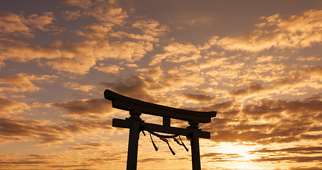 Image showing Torii gate, sunset sky in Japan with nature, zen and spiritual history on travel adventure. Shinto architecture, Asian culture and calm clouds on Japanese landscape with sacred monument at shrine.