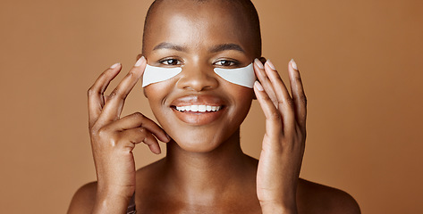 Image showing Face, beauty or happy black woman with eye patch for skincare or wellness isolated on brown background. Studio, smile or model with facial collagen pads, dermatology product or anti aging cosmetics