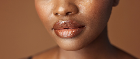 Image showing Closeup, lips and black woman with beauty, smile and skincare on a brown studio background. African person, girl and model with gloss, cosmetics and dermatology with clear skin, smooth and aesthetic
