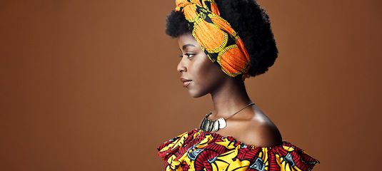 Image showing Culture, African fashion or face of black woman in studio on a brown background for trendy style. Unique, beauty or model with confidence, pride or afro posing in wrap, clothes or traditional outfit