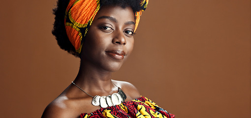 Image showing Culture, African fashion or face of black woman in studio on a brown background for trendy style. Unique, beauty or model with confidence, pride or afro posing in wrap, clothes or traditional outfit