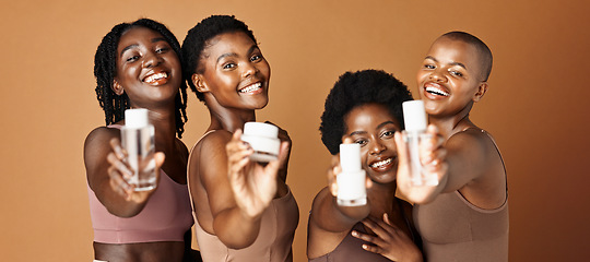 Image showing Happy black woman, skincare and beauty products for tone or foundation against a brown studio background. Group portrait of African female people or model smile together with skin makeup on mockup