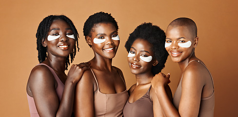 Image showing Face, happy or black women with eye patch for skincare or beauty isolated on brown background. Studio, smile or African models with facial collagen pads, dermatology product or anti aging cosmetics
