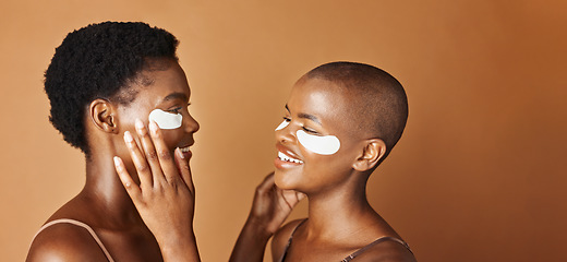 Image showing Beauty, eye pads and face of black women in studio with glowing, natural and facial routine. Smile, skincare and portrait of African female friends with cosmetic treatment by brown background.