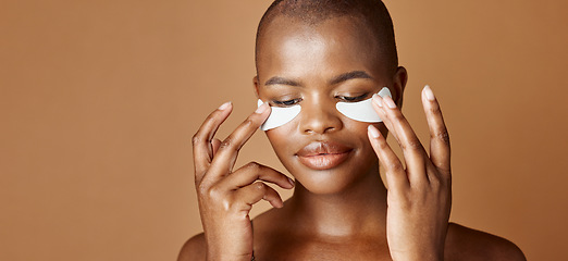 Image showing Face, beauty or happy black woman with eye patch for skincare or wellness isolated on brown background. Studio, smile or model with facial collagen pads, dermatology product or anti aging cosmetics