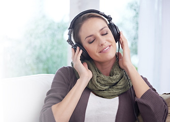 Image showing Home, smile and woman with headphones, listening to radio and peaceful with weekend break and joyful. Apartment, podcast and person on a couch and headset for audio, sound and streaming music