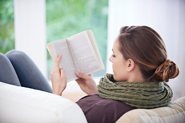 Image showing Woman, book and reading from the back on sofa for story, novel and learning knowledge in living room at home. Lady, fiction books and relax with literature, hobby and comfortable on couch in lounge