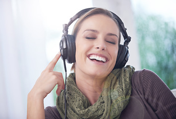 Image showing Home, funny and woman with headphones, listening to radio and peaceful with weekend break and calm. Apartment, laughing and person on sofa and headset for audio, sound and streaming music with humor