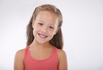 Image showing Child, girl and portrait or smile in studio with confidence, positive attitude and carefree youth. Kid, face and happiness with calm expression, mock up space and casual outfit on white background