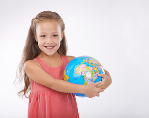 Image showing Child, portrait and world globe for education school learning in studio for Geography, continents or white background. Girl, student and planet for class studying Earth population, travel or mockup