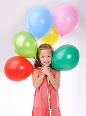 Image showing Girl, child and birthday balloons in portrait, party decoration and smiling for milestone event in studio. Happy female person, inflatable accessory and joy on white background, playful and celebrate