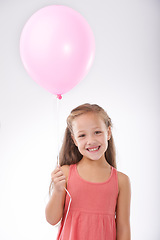 Image showing Girl, child and balloon in portrait, party decoration and smiling for milestone event in studio. Happy female person, inflatable accessory and birthday joy on white background, playful and celebrate