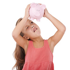 Image showing Girl child, piggy bank and shake for savings, studio and thinking with search for money by white background. Confused kid, container or animal toys for coins, cash or learning for financial education
