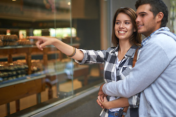 Image showing Bakery, pointing and couple with love, smile and conversation with romance, customer and cheerful. Outdoor, happy man and woman with embrace, shopping or sale with cakes, discount deal and discussion