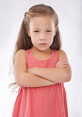 Image showing Angry, girl and child in studio with arms crossed, frustrated in portrait and emotion, cross or upset on white background. Facial expression, rage and conflict with tantrum, furious and bad attitude