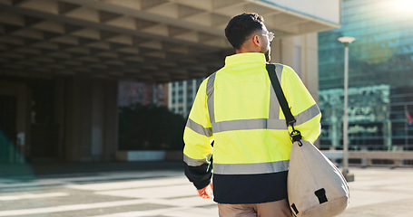 Image showing Man, back and architect walking in city for construction, maintenance or building at outdoor site. Rear view of male person, engineer or contractor carrying bag for project, architecture or plan