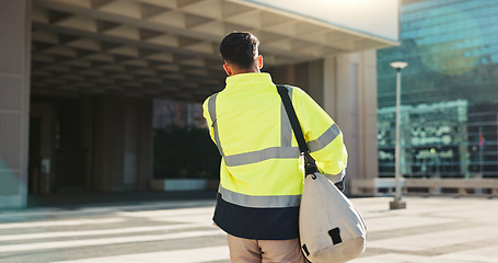 Image showing Man, back and architect walking in city for construction, maintenance or building at outdoor site. Rear view of male person, engineer or contractor carrying bag for project, architecture or plan