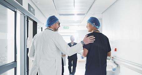 Image showing Doctor, nurse and talk while walk in hospital with advice, consult or communication with medical team. People, discuss or coaching for patient care, treatment and wellness after surgery with joke