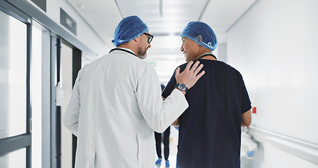 Image showing Doctor, nurse and talk while walk in hospital with advice, consult or communication with medical team. People, discuss or coaching for patient care, treatment and wellness after surgery with joke