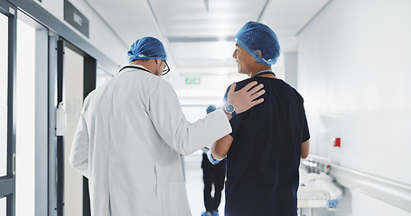 Image showing Doctor, nurse and talk while walk in hospital with advice, consult or communication with medical team. People, discuss or coaching for patient care, treatment and wellness after surgery with joke